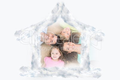 Composite image of happy family lying on the rug in a circle