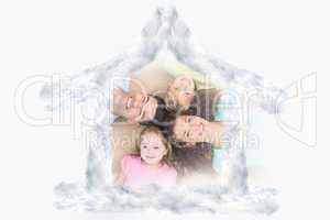 Composite image of happy family lying on the rug in a circle