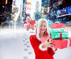 Composite image of festive blonde holding pile of gifts