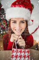 Composite image of festive redhead holding christmas gifts