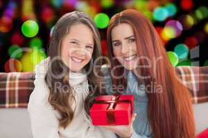 Composite image of mother and daughter with gift