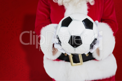 Composite image of mid section of santa holding football
