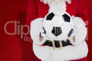 Composite image of mid section of santa holding football