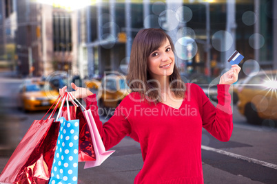 Composite image of brunette holding gift and credit card