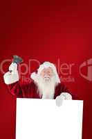 Composite image of santa holds a sign and rings his bell