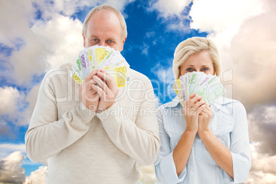 Composite image of happy mature couple smiling at camera showing