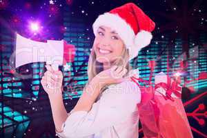 Composite image of festive blonde holding megaphone and bags