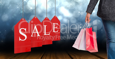 Composite image of smiling woman holding shopping bag
