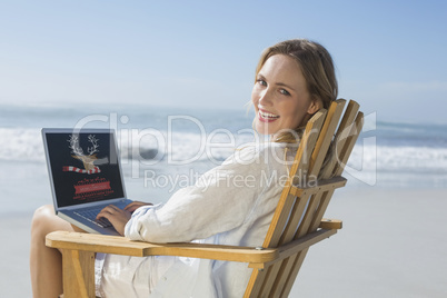 Composite image of gorgeous blonde sitting on deck chair using l