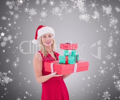 Composite image of pretty blonde hoding christmas gifts