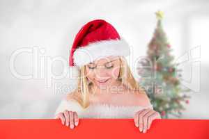 Composite image of festive cute blonde holding poster