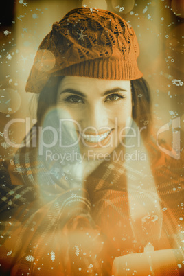 Composite image of smiling brunette with cover and red hat