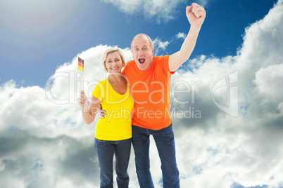 Composite image of happy german couple cheering at camera