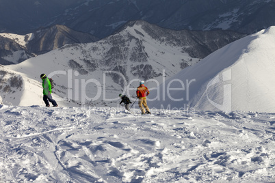 Freeriders on off-piste slope in sun evening