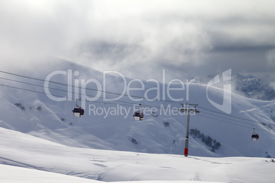 Gondola lifts and off-piste slope in mist