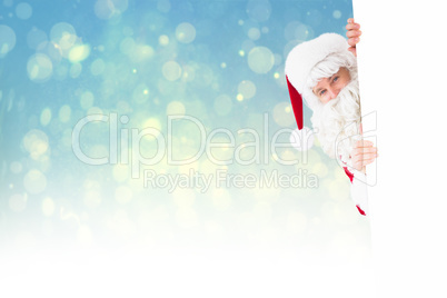 Composite image of smiling santa claus presenting sign