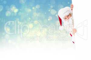 Composite image of smiling santa claus presenting sign