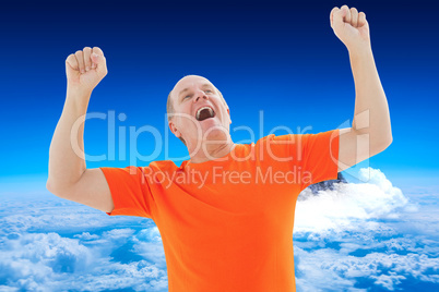 Composite image of mature man in orange tshirt cheering