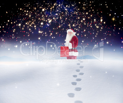 Composite image of santa carrying gifts in the snow