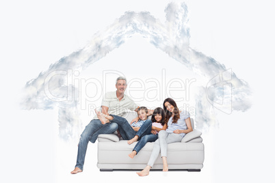 Composite image of family sitting on sofa smiling at camera