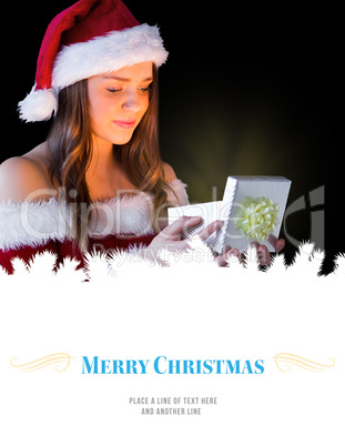 Composite image of pretty brunette in santa outfit opening gift