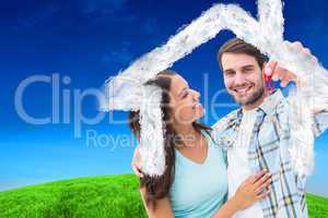 Composite image of happy young couple showing new house key