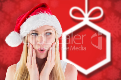 Composite image of festive blonde looking surprised with hands o