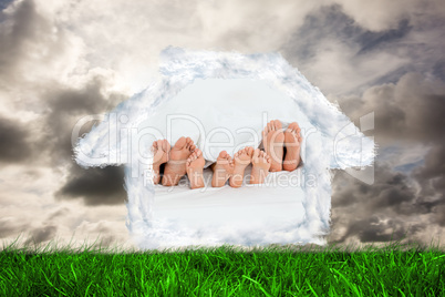 Composite image of  family on the bed at home with their feet sh