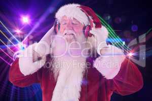 Composite image of santa claus enjoys some music