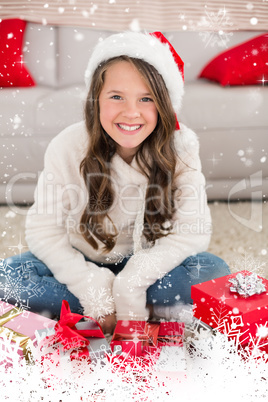 Composite image of festive little girl smiling at camera with gifts