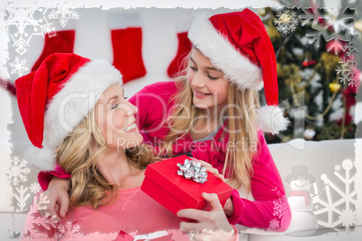 Composite image of festive mother and daughter with gift