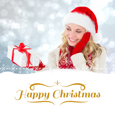 Composite image of happy festive blonde with gift