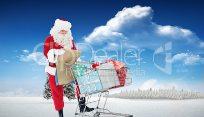 Composite image of santa delivering gifts with a trolley