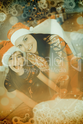 Composite image of festive mother and daughter using tablet pc