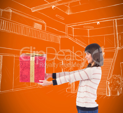 Composite image of cute young woman holding a gift