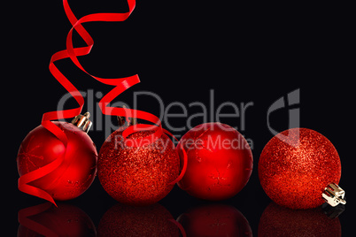 Composite image of four red christmas ball decorations