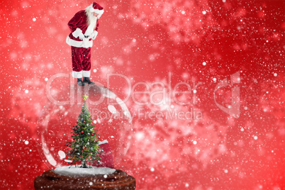 Composite image of santa standing on snow globe