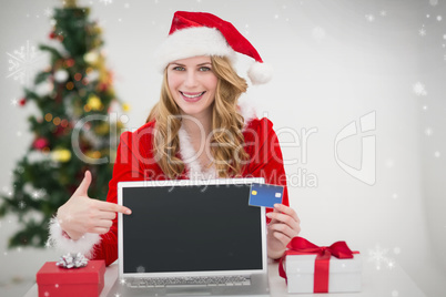 Composite image of festive blonde shopping online with laptop an