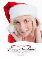 Composite image of young blonde woman putting on the santa claus