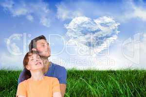 Composite image of happy couple together looking upwards