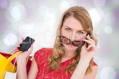 Composite image of pretty blonde in sunglasses holding shopping