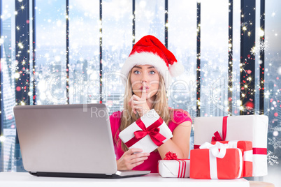 Composite image of festive blonde shopping online with laptop