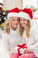 Composite image of festive mother and daughter smiling at camera