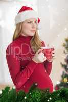 Composite image of festive pregnant woman holding mug while standing