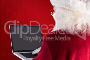 Composite image of santa claus uses a laptop