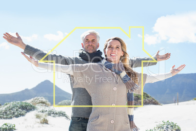 Composite image of carefree couple standing on the beach in warm