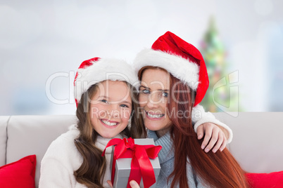 Composite image of mother and daughter with gift