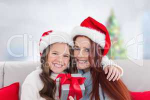 Composite image of mother and daughter with gift