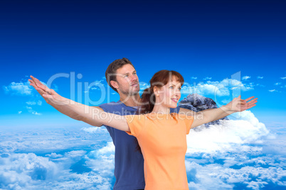 Composite image of happy couple looking upwards