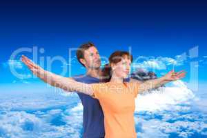 Composite image of happy couple looking upwards